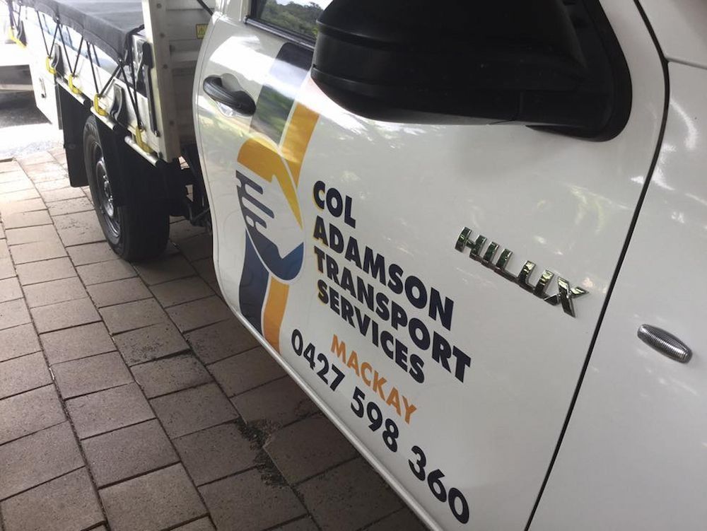 White Toyota Hilux Truck With Logo, Parked on Pavers — Col Adamson Transport Services in Dysart, QLD