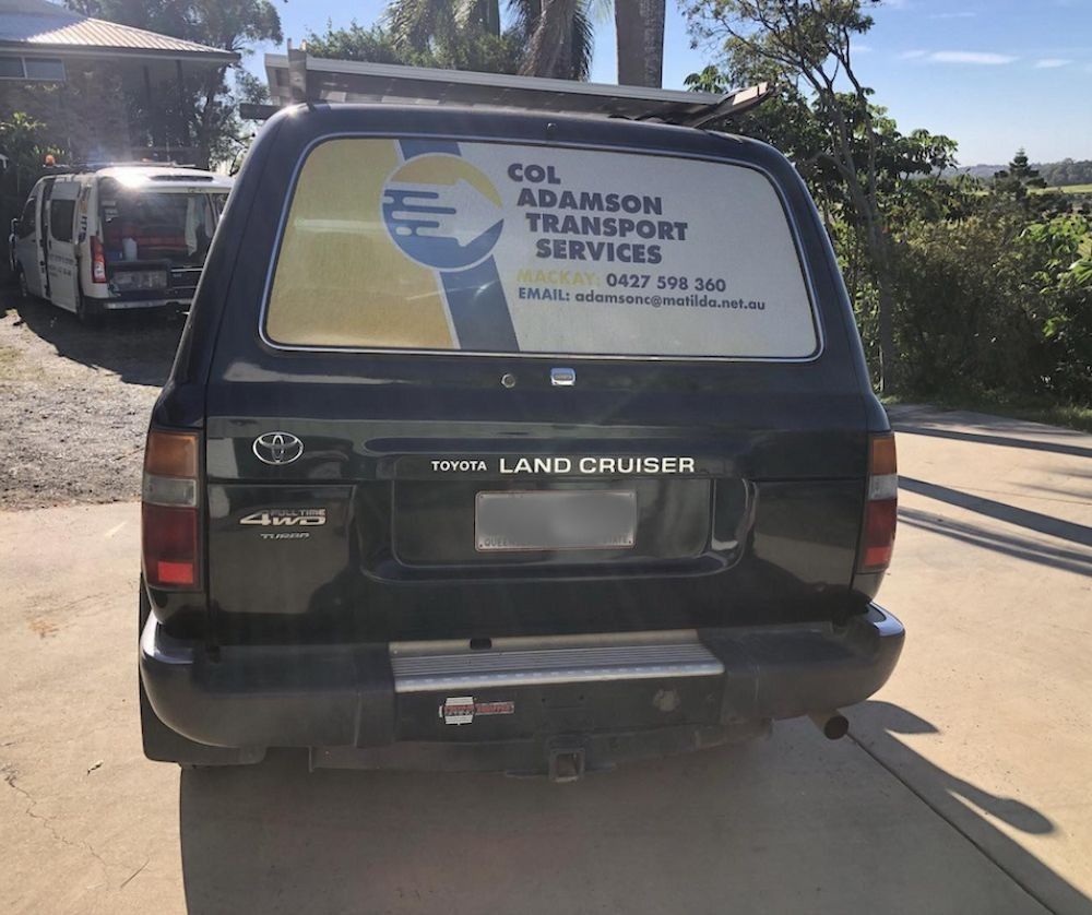 Black Toyota Land Cruiser With Business Sign on the Back Window — Col Adamson Transport Services in Emerald, QLD