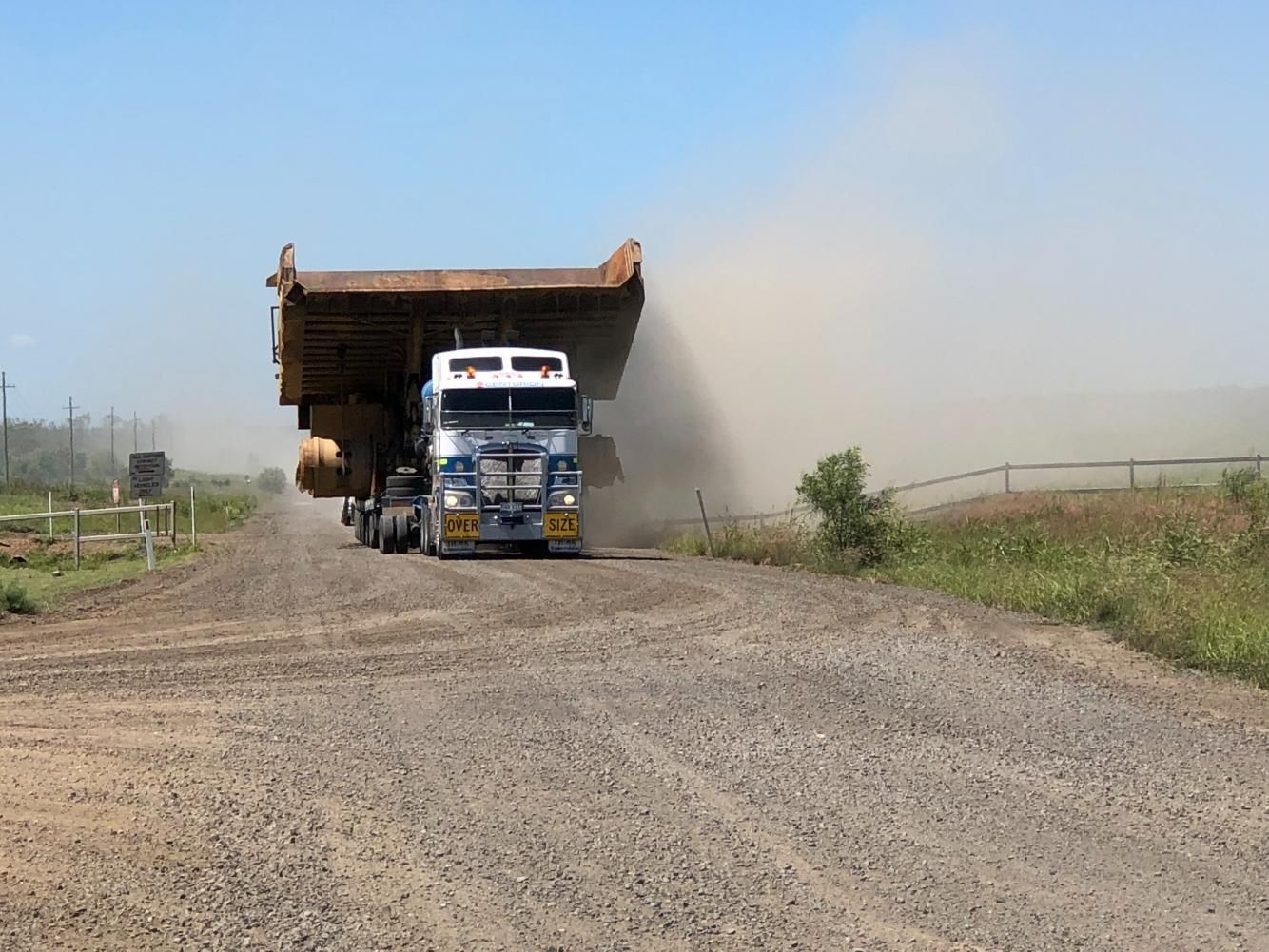 Large Dump Truck Driving on a Gravel Road, Kicking Up Dust — Col Adamson Transport Services in Farleigh, QLD