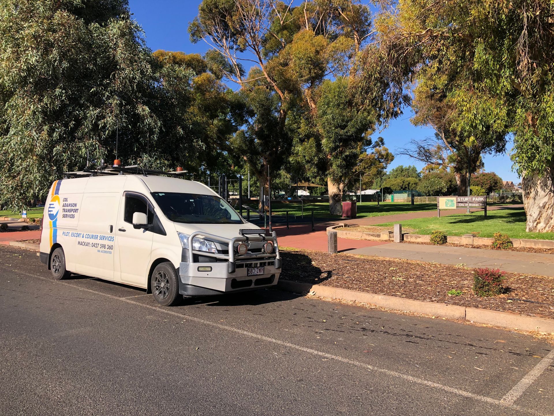White Van Parked on Street Next to Park — Col Adamson Transport Services in Dysart, QLD
