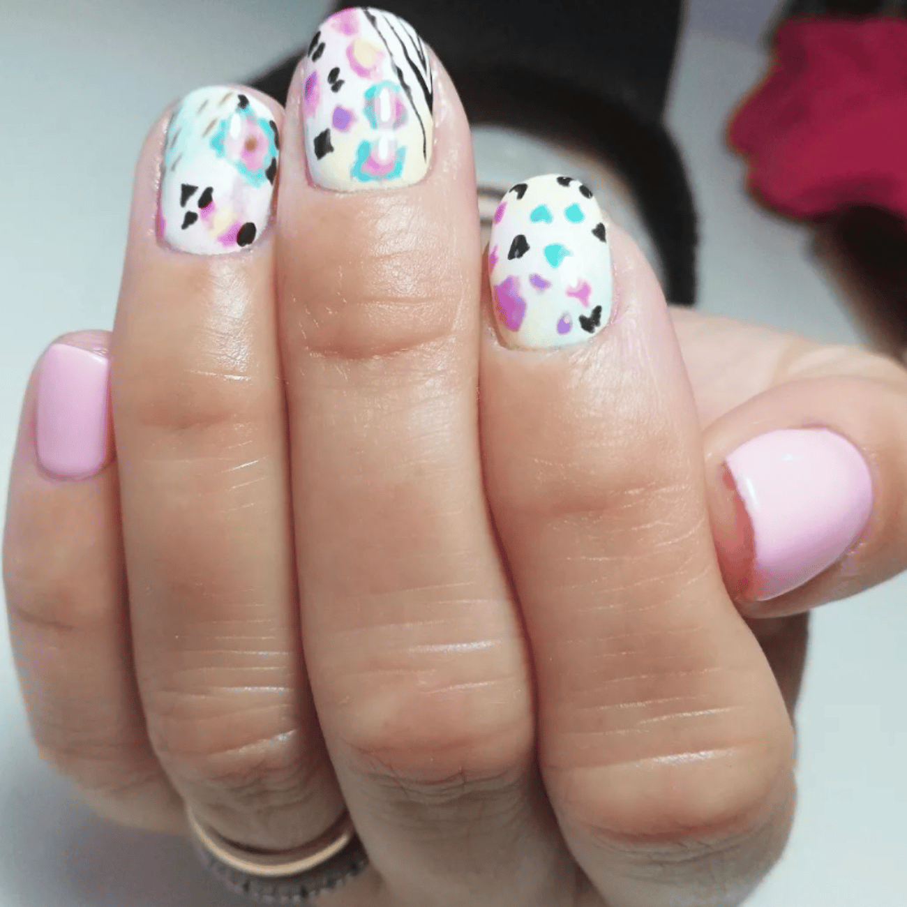 Un primer plano de las uñas de una mujer con un diseño de estampado de leopardo.