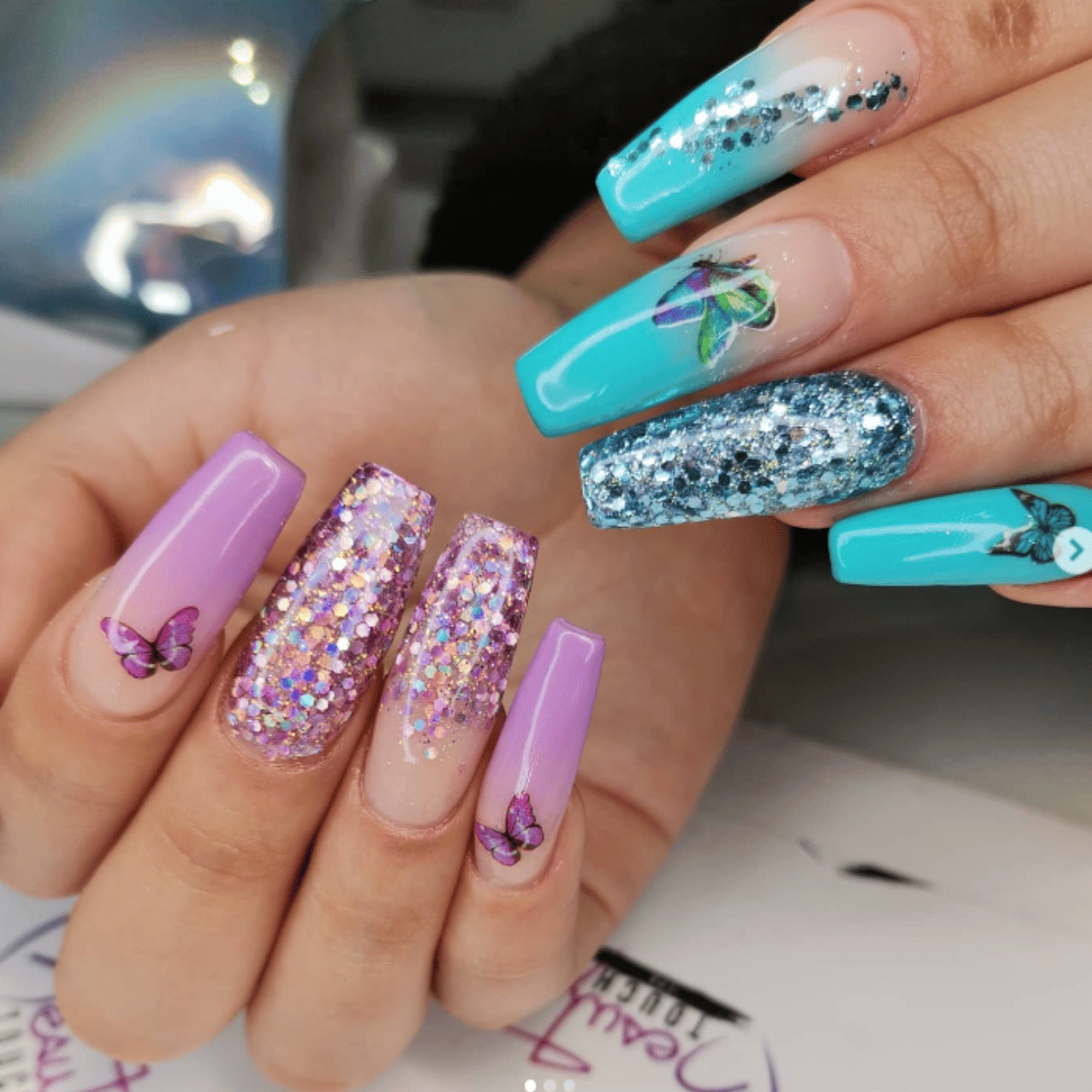 Un primer plano de las uñas de una mujer con un diseño azul y morado.