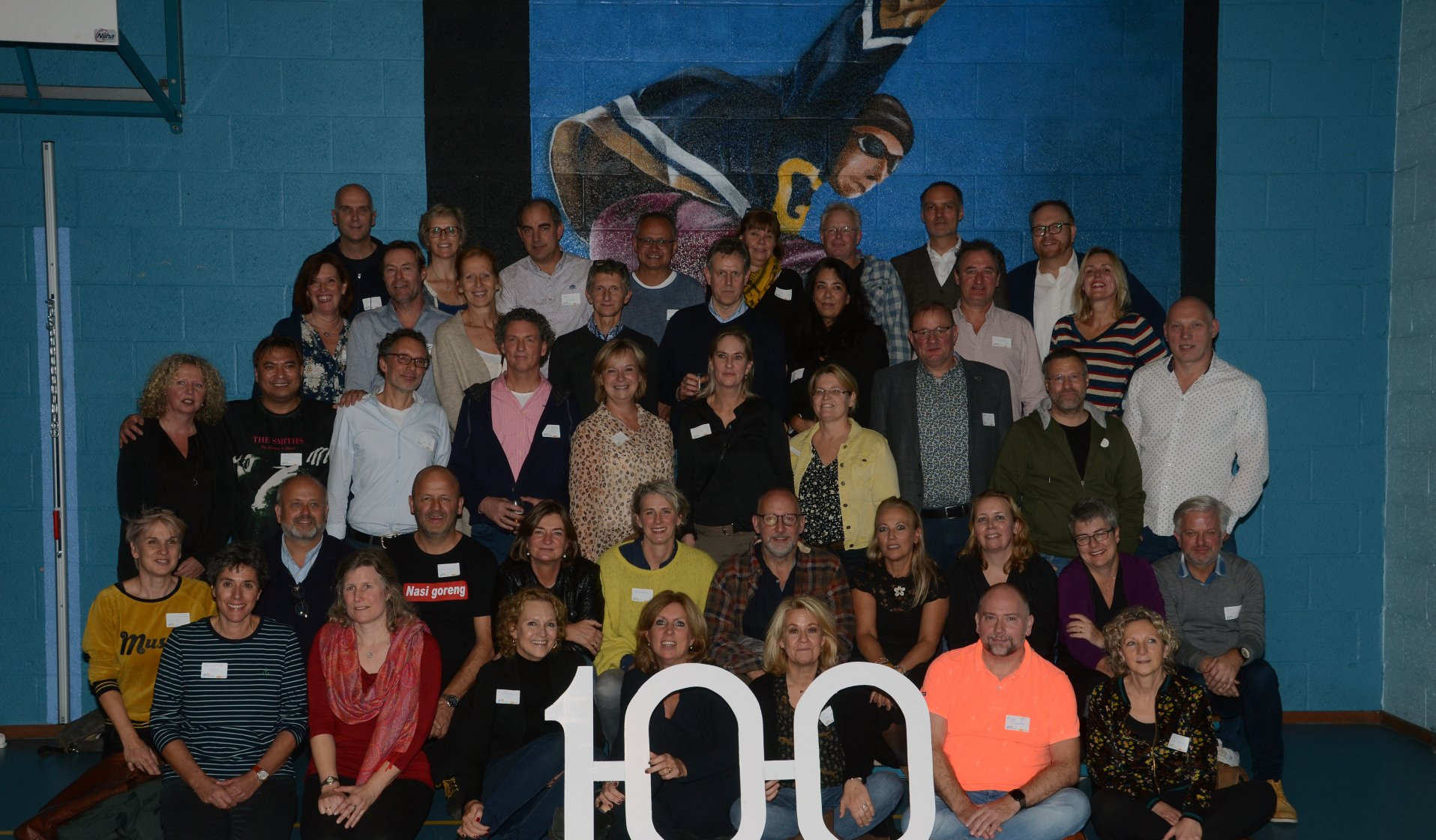 Een groep mensen poseert met een uitgesneden 