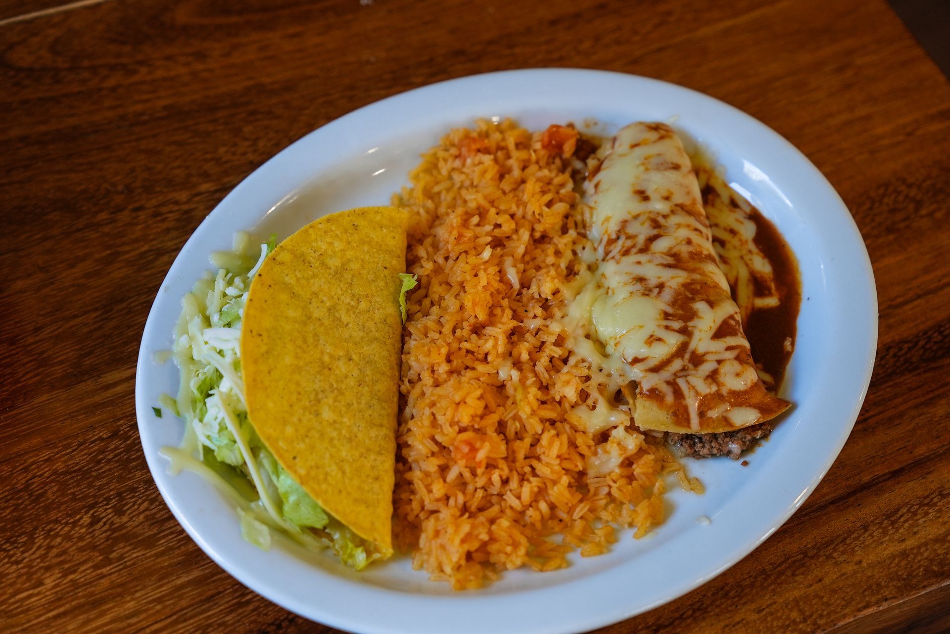 A plate of mexican food with rice and a taco