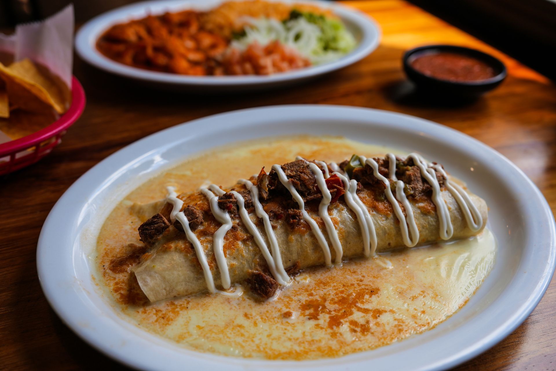 A burrito with meat and cheese on a white plate