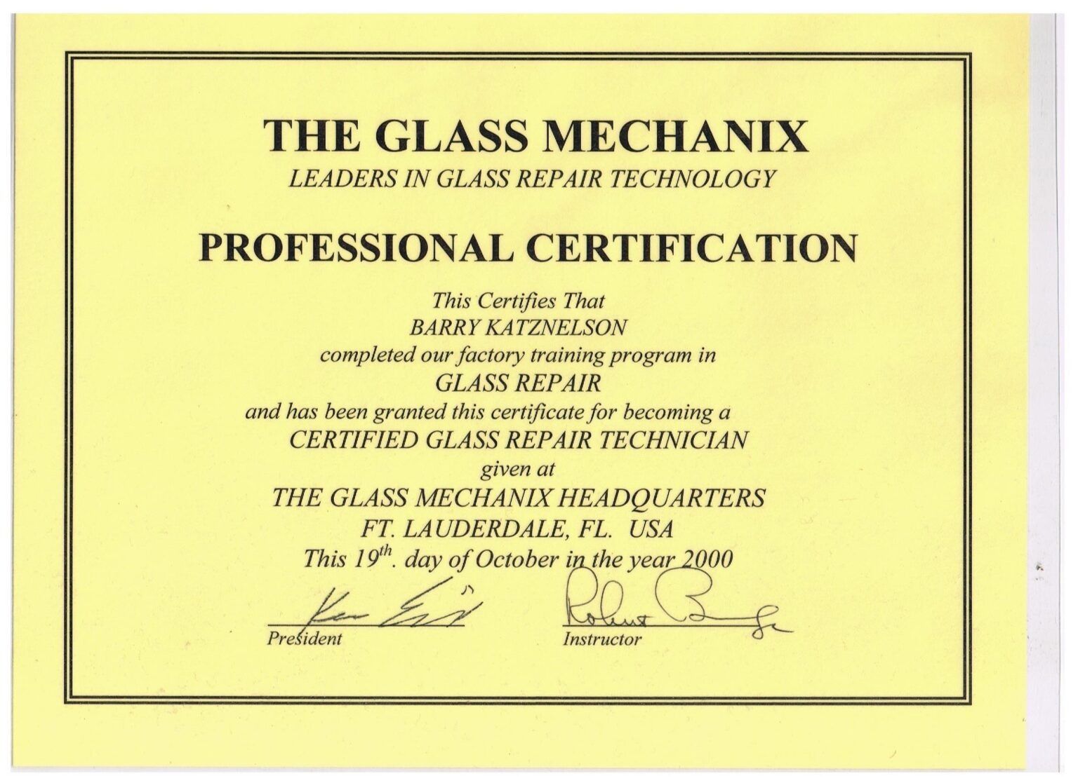 Yellow professional certification plaque from The Glass Mechanix for glass repair technician credentials