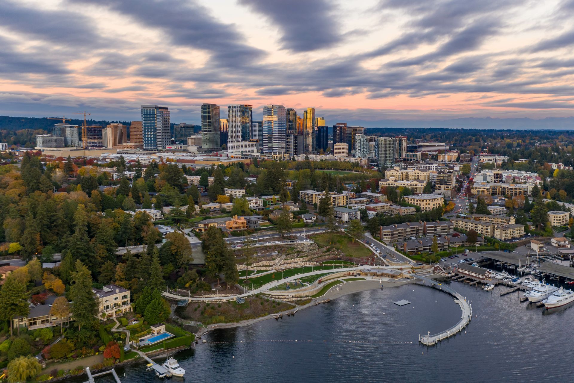 An aerial view of a city with a lake in the foreground and a city skyline in the background.