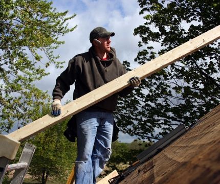 worker holding wood in hand