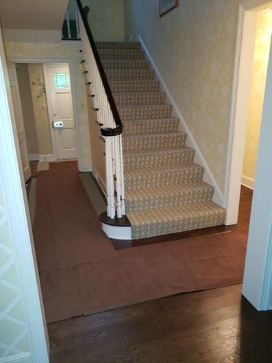 A staircase with a carpeted staircase and a wooden railing in a hallway.