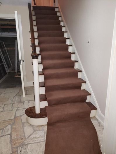 A staircase with a brown carpet on the steps
