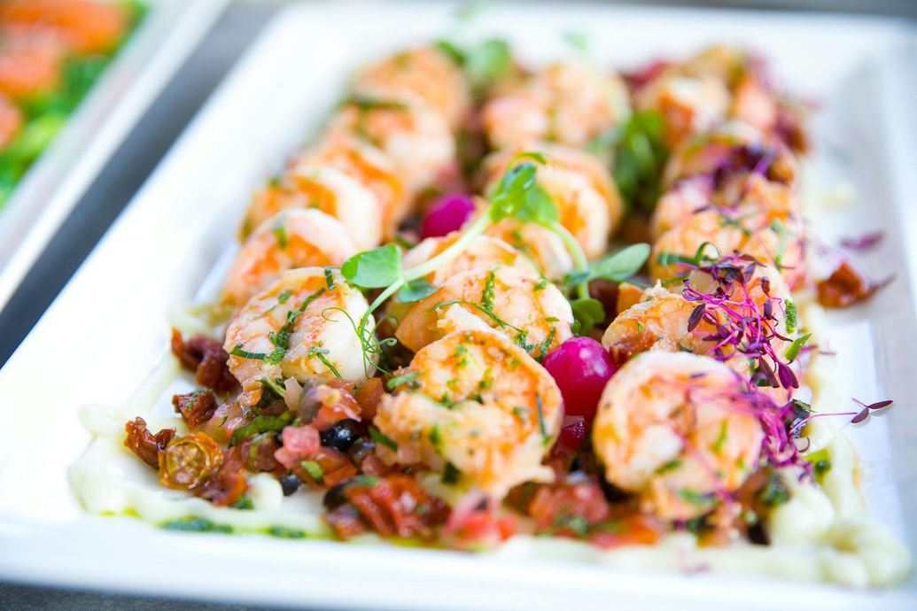 A white plate topped with shrimp and vegetables