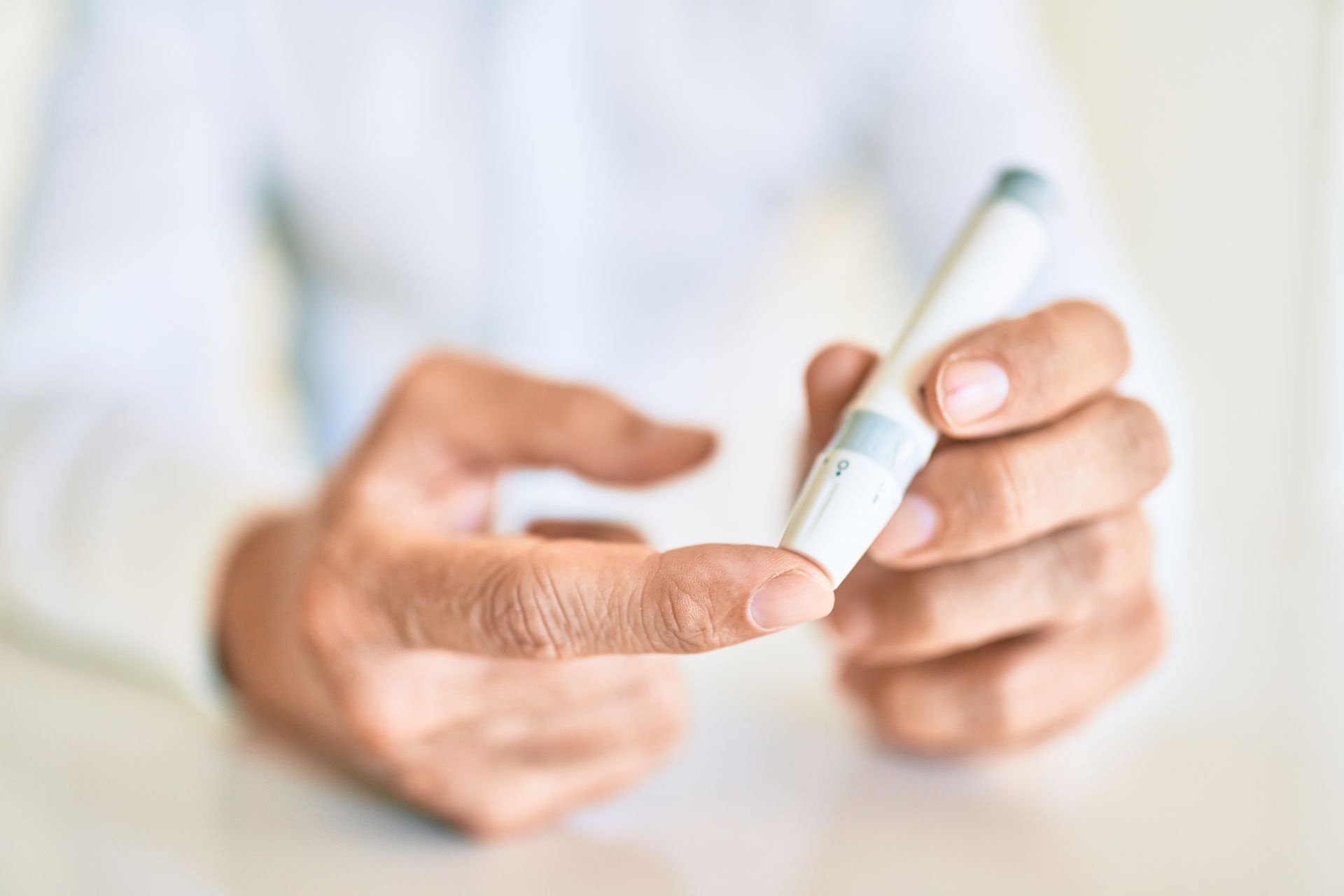 Person using a finger-prick device to test blood glucose levels.