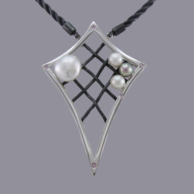 A silver kite-shaped pendant on a dark cord, featuring a black grid design with one large and three small white pearls.