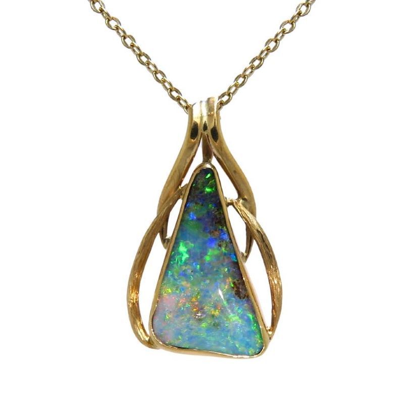 Gold pendant necklace featuring a triangular opal with vibrant blue and green flashes, set in a flowing metal frame.