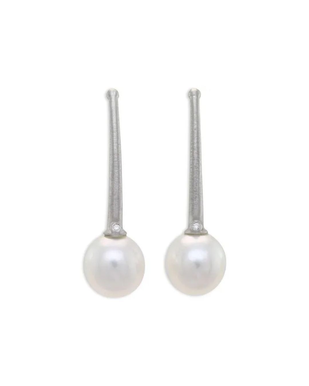 A pair of vertical, textured silver earrings, each featuring a small diamond accent atop a spherical white pearl.
