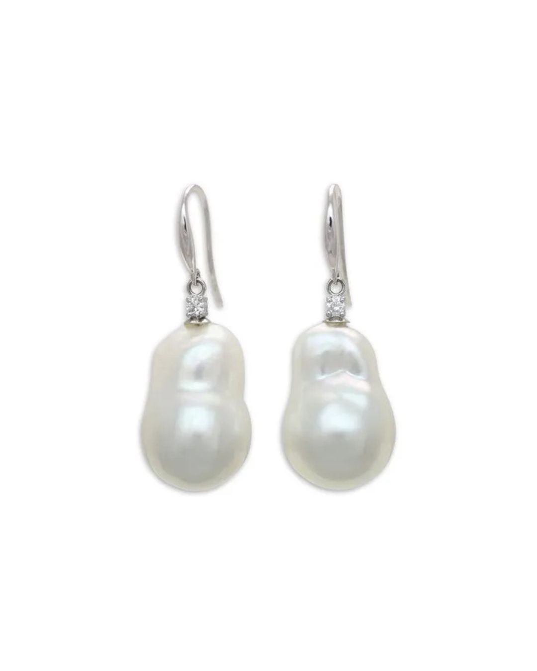 A pair of white baroque pearl drop earrings, each set with a small diamond on a silver hook.
