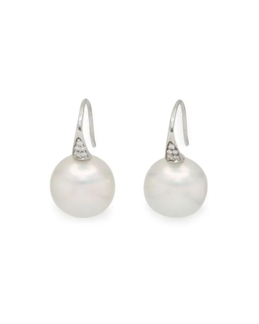 A pair of silver drop earrings featuring a large, round white pearl suspended from a small, diamond-encrusted bail.