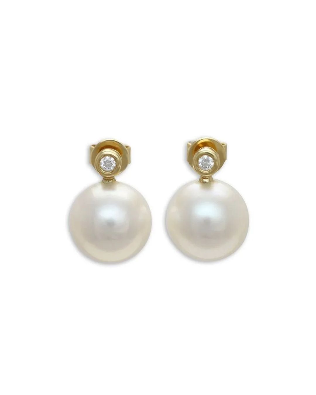 A pair of gold earrings featuring a round, white pearl dangling beneath a small, bezel-set diamond stud.