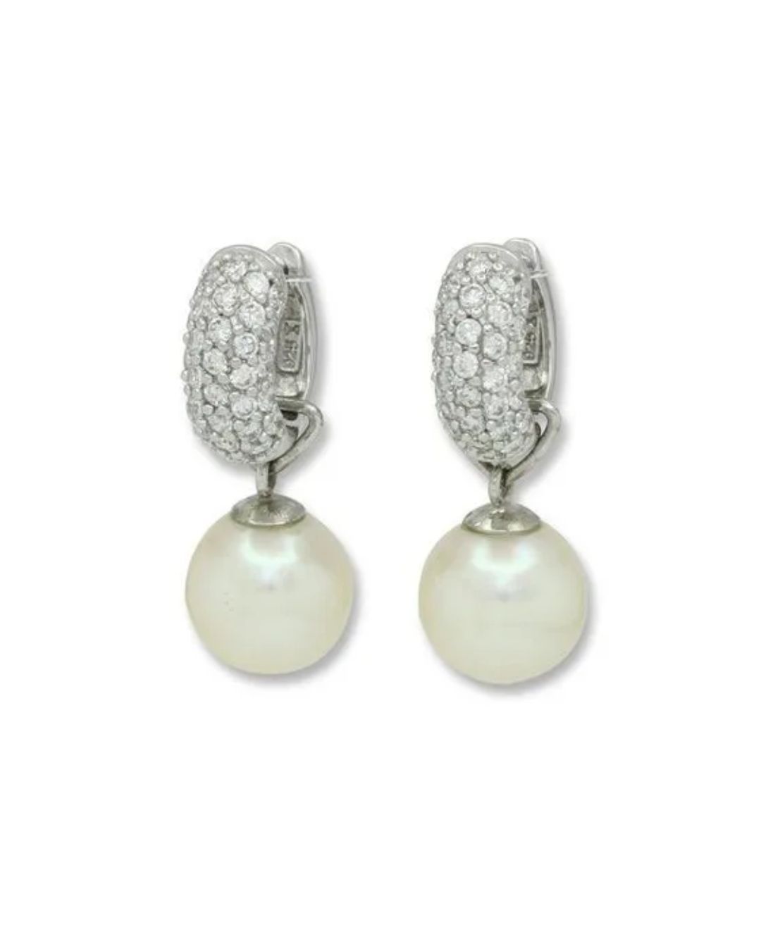 A pair of silver hoop earrings paved with white stones, each featuring a dangling, round white pearl.