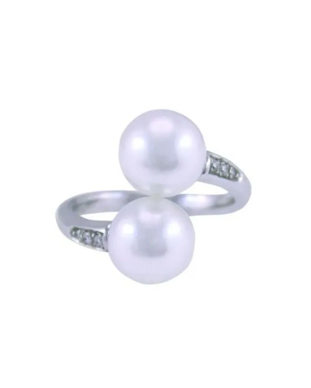 A silver bypass ring featuring two white pearls and small accent stones set on the band.
