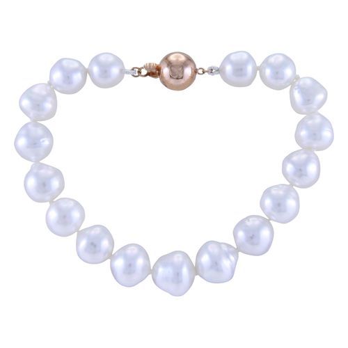 A bracelet of white spherical pearls accented with a large, irregular baroque pearl, worn on a wrist.