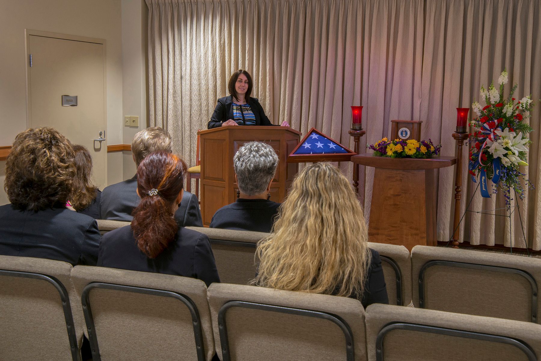 a woman is giving a speech to a group of people in a church .