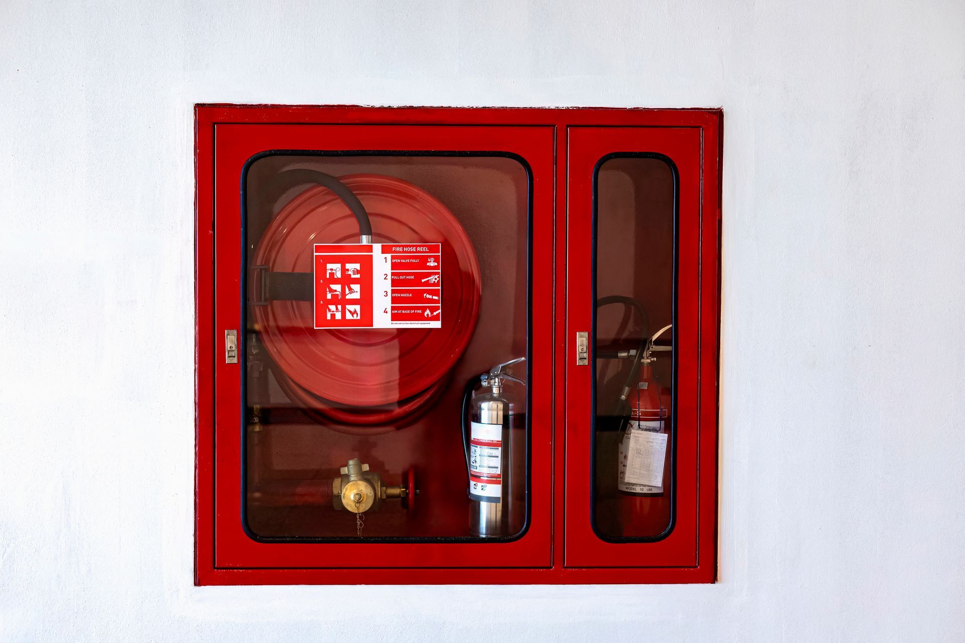 A red box with a fire hose and a fire extinguisher inside of it