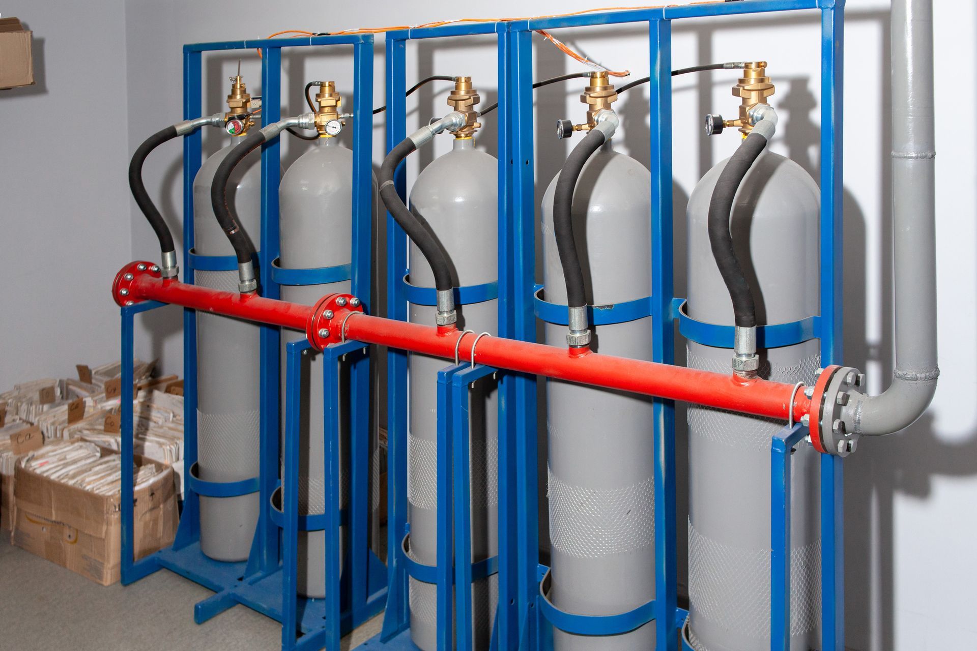 A row of gas cylinders are lined up in a room.