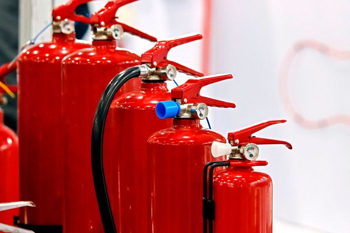 A row of red fire extinguishers are lined up in a row.