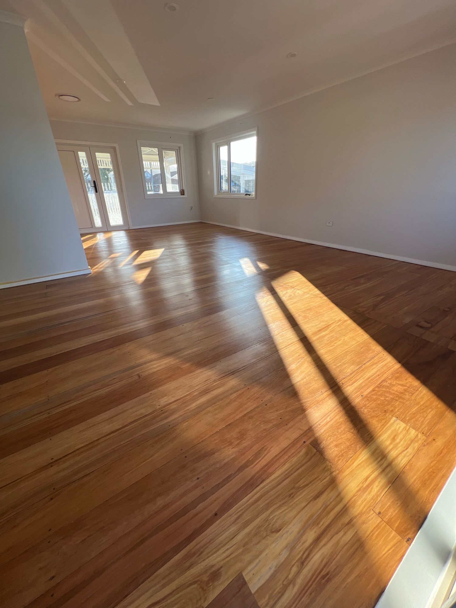 An empty room with wooden floors and a fireplace