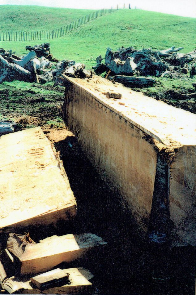 A large concrete block is sitting in the middle of a field.