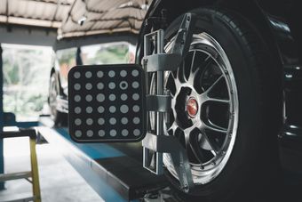 A car tire with an alignment tool attached in a garage | Chet's Wheel Alignment