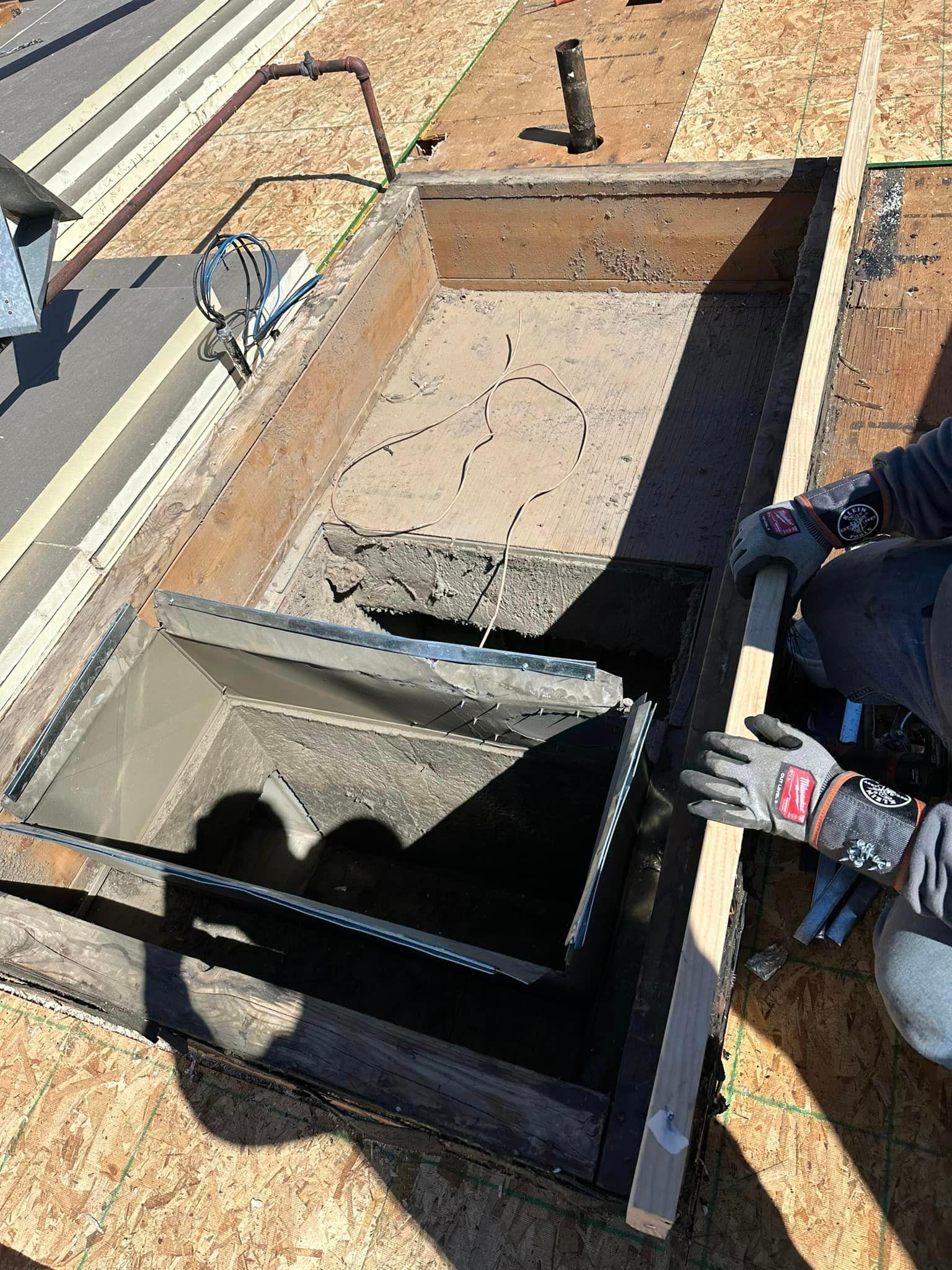 A person is laying concrete in a hole in the ground.