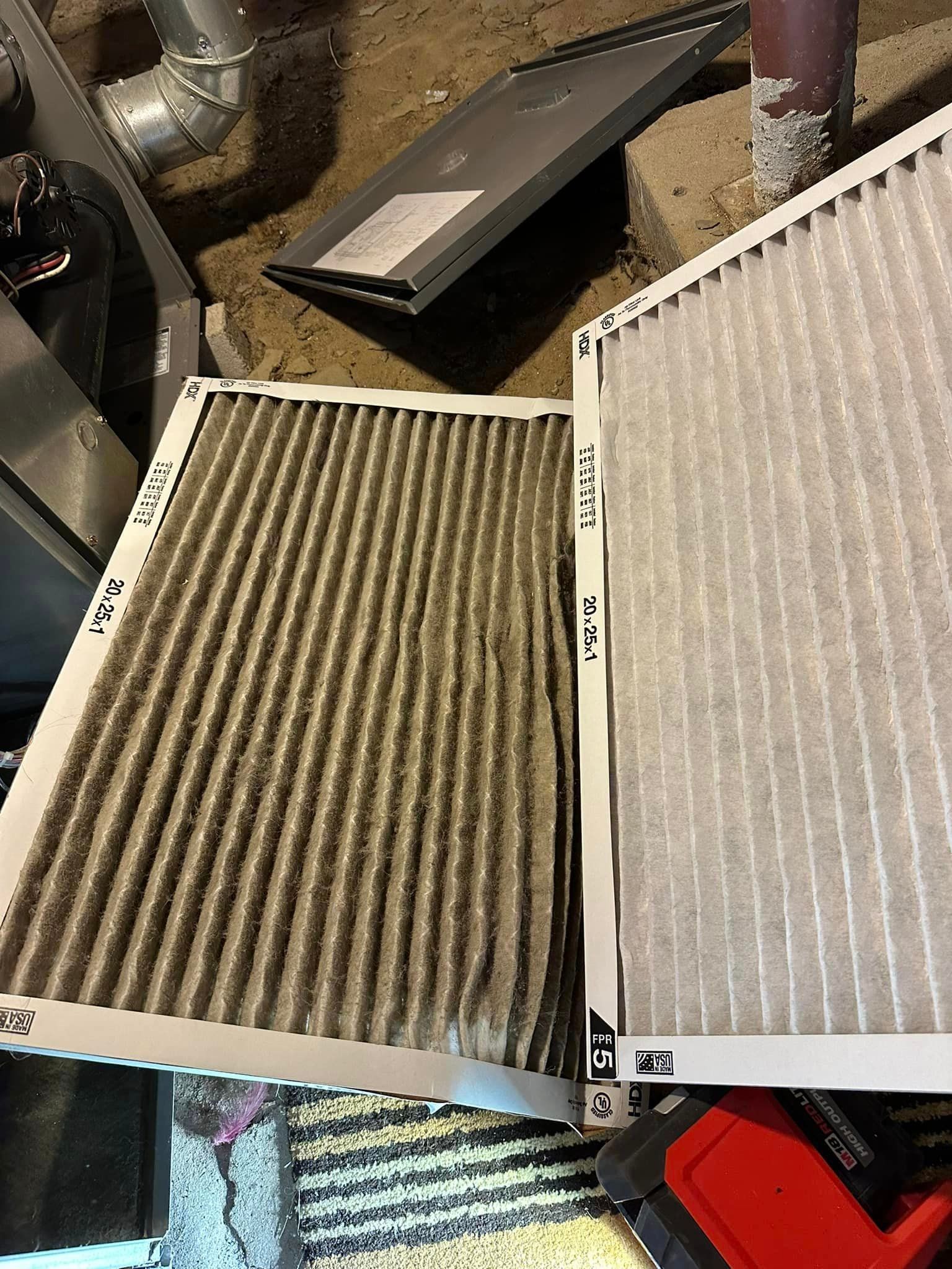 Two air filters are sitting on top of each other on the floor.