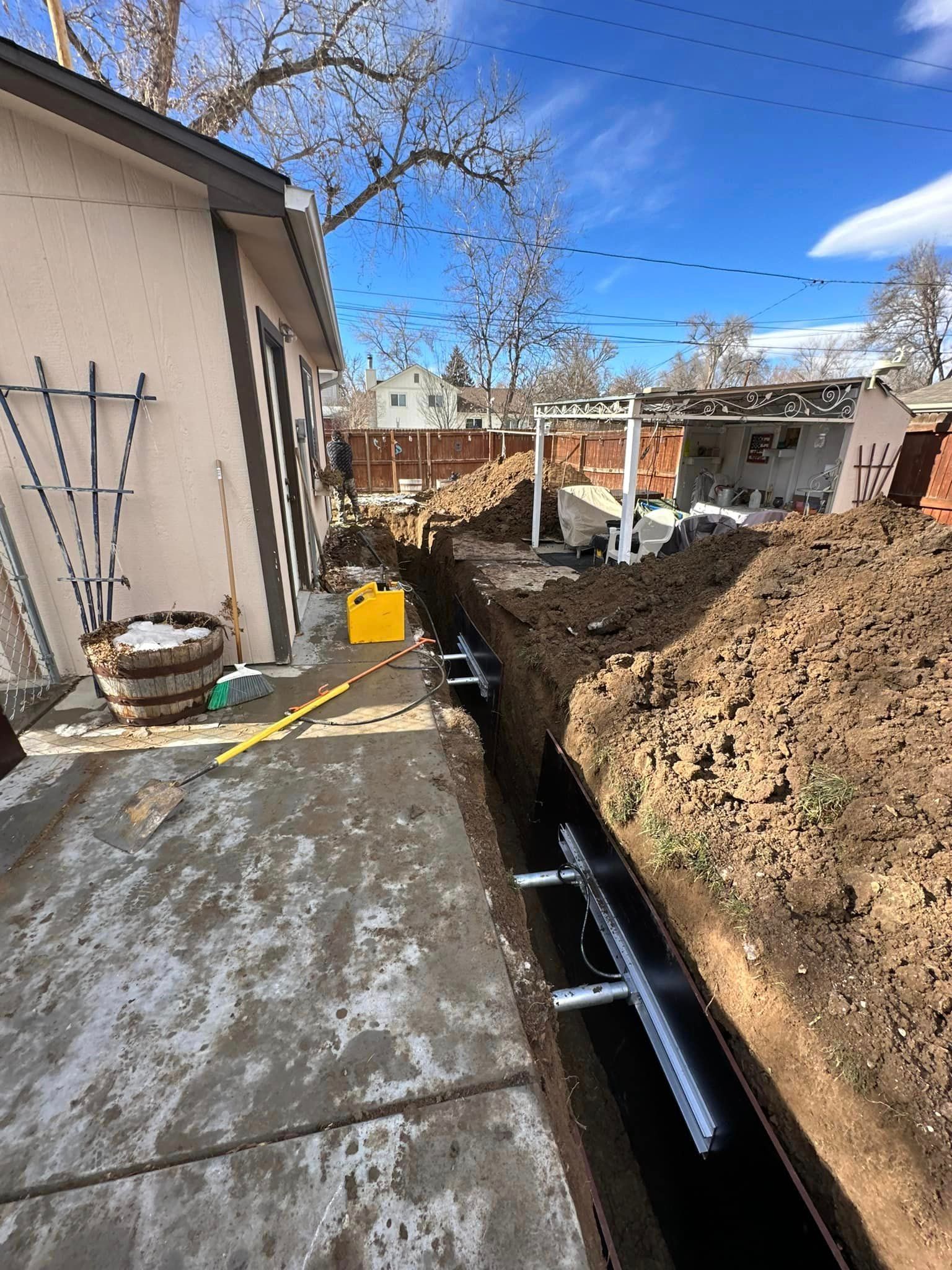 A drainage system is being installed in the backyard of a house.