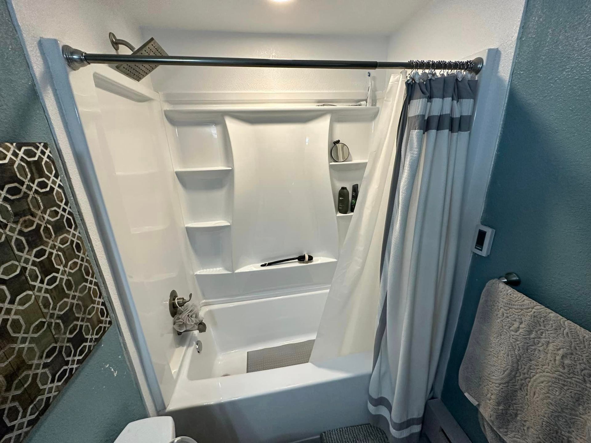 A bathroom with a bathtub and shower curtain.