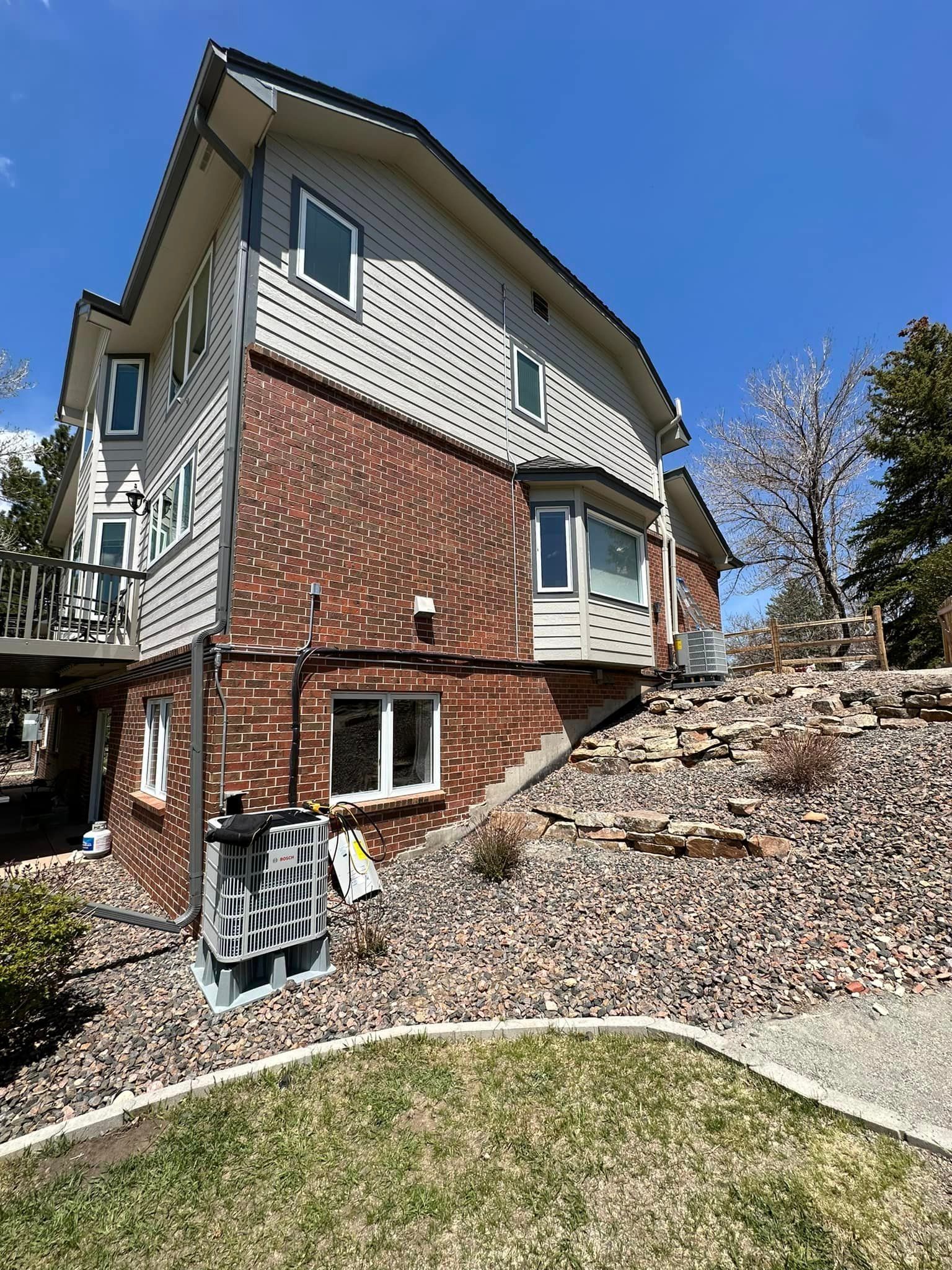A large brick house with a lot of windows is sitting on top of a hill.