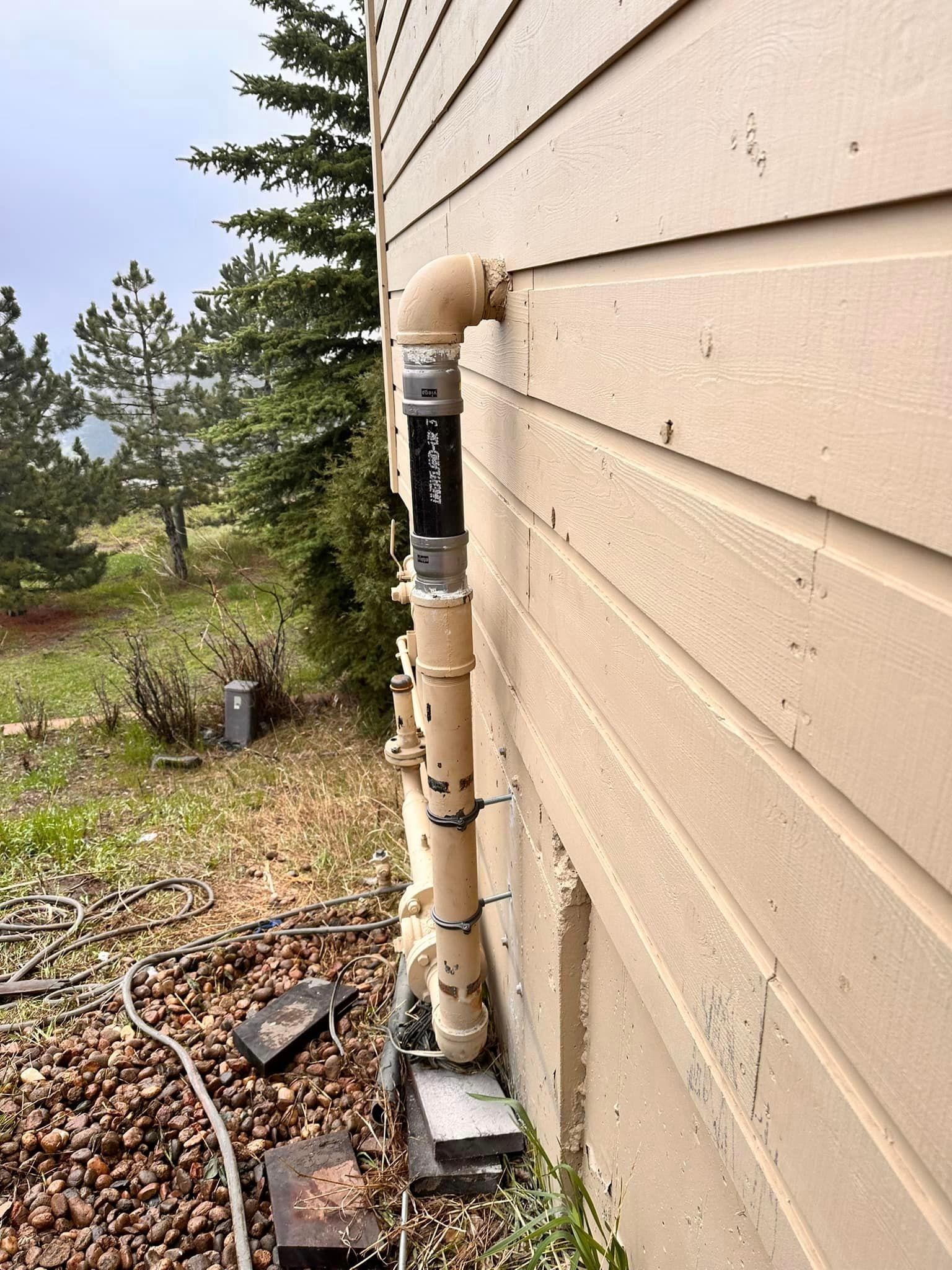 A pipe is attached to the side of a house.