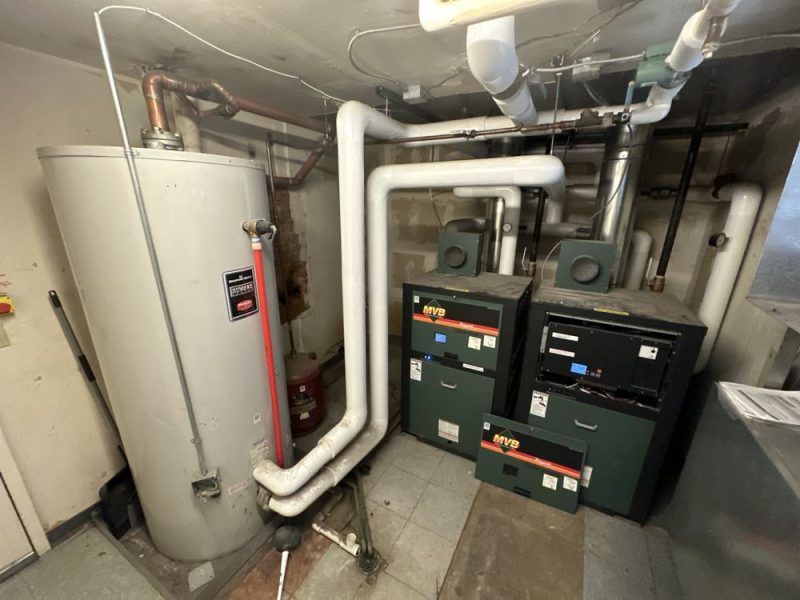 A room with a water heater , boiler , and safes.