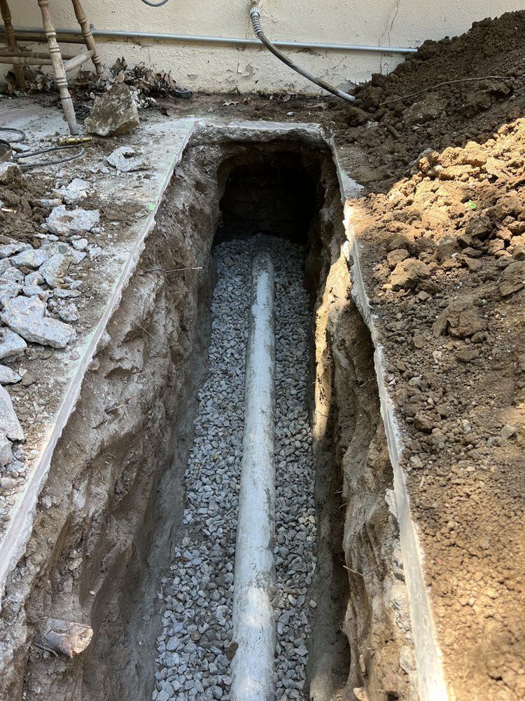 A drain pipe is being installed in a hole in the ground.