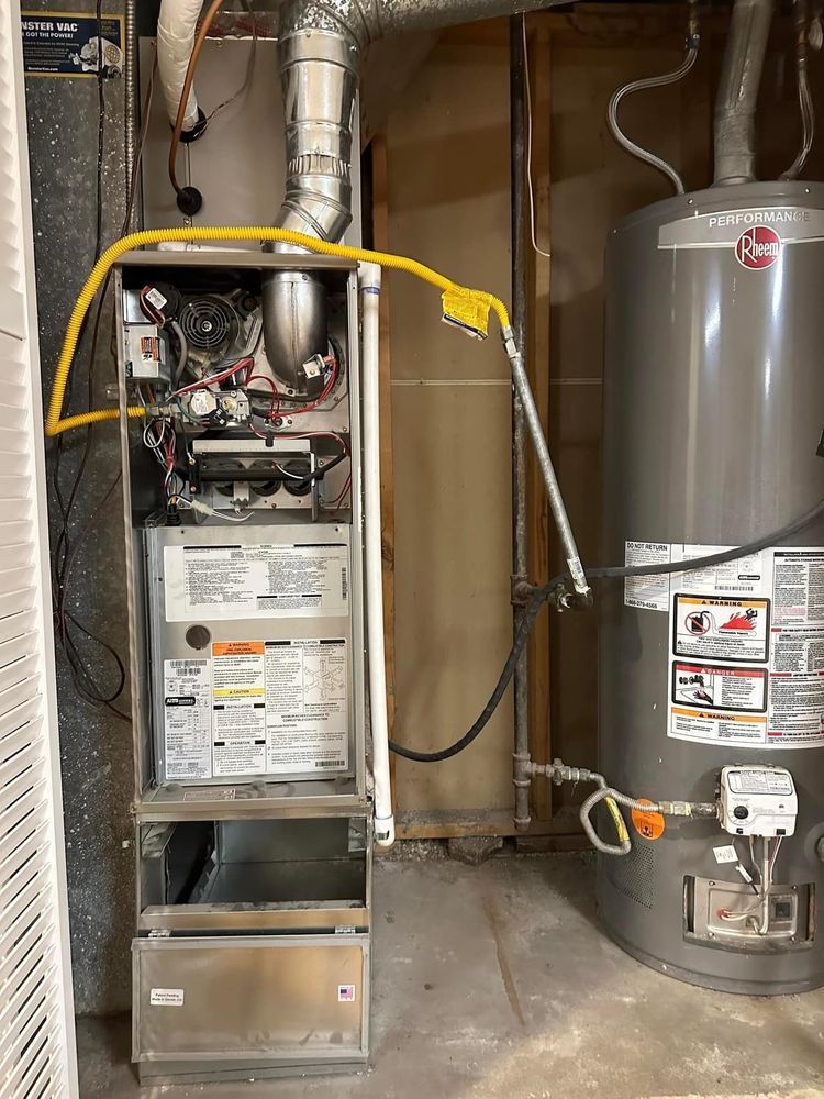 A gas heater and a water heater are in a basement.