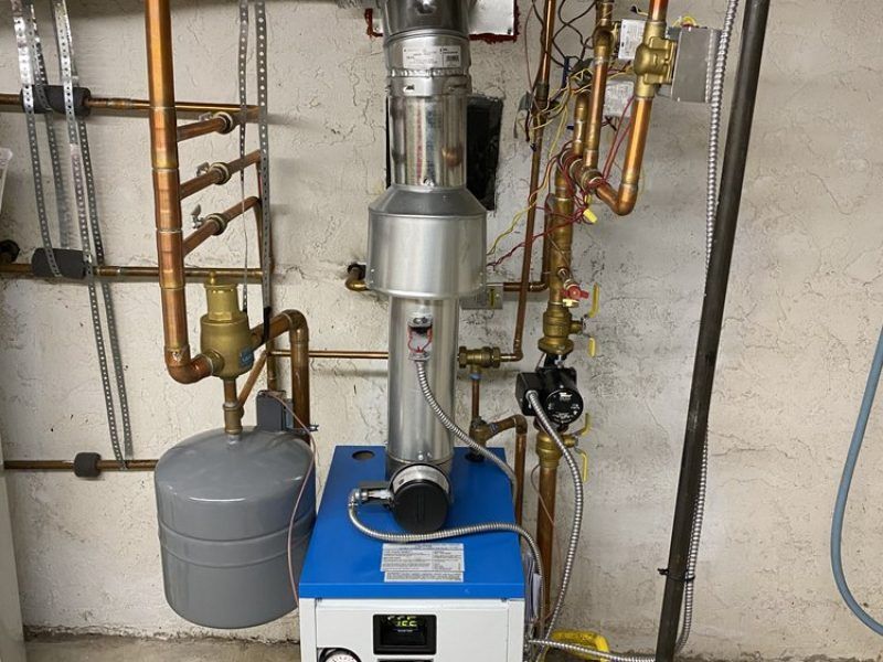 A blue and white boiler with copper pipes attached to it.