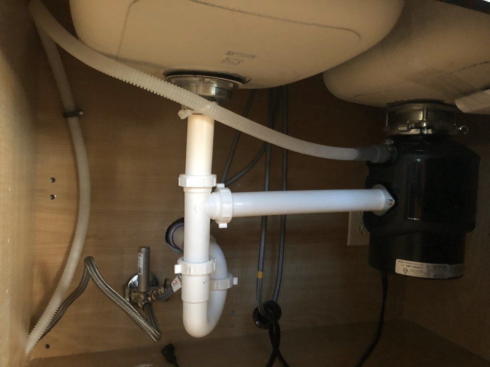 A sink with a white pipe underneath it