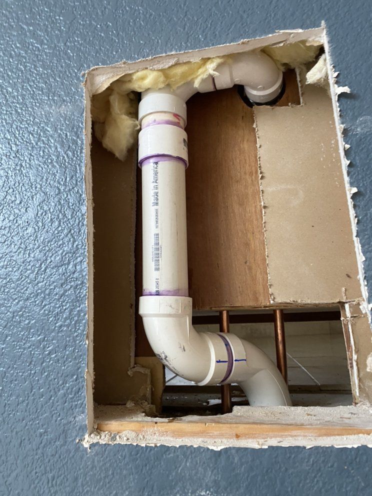 A pipe is coming out of a hole in the wall.