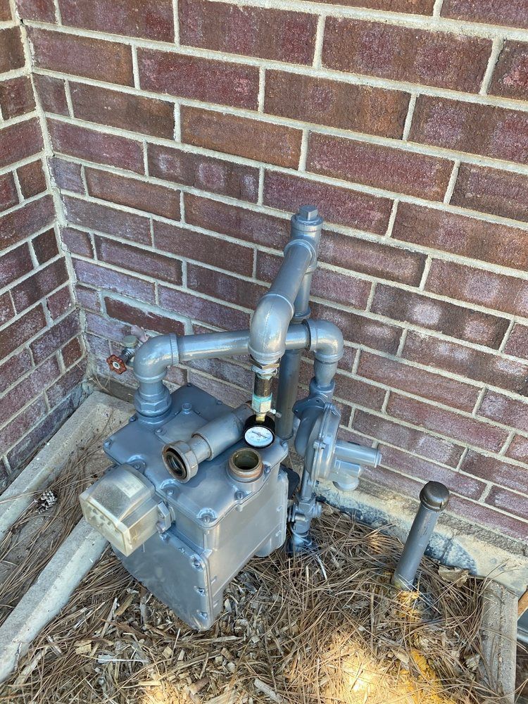 A brick wall with a lot of pipes coming out of it.