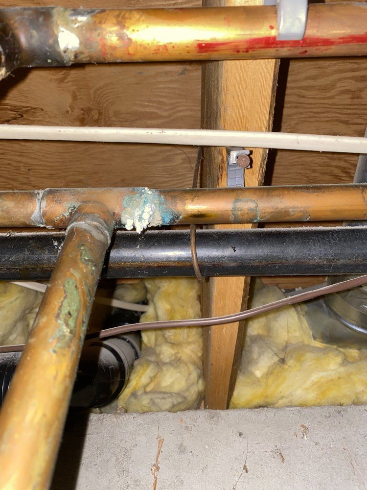 A bunch of pipes are hanging from the ceiling of a house.