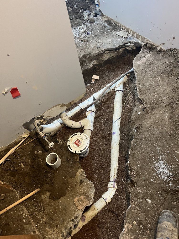 A bunch of pipes are laying on the ground in a room.