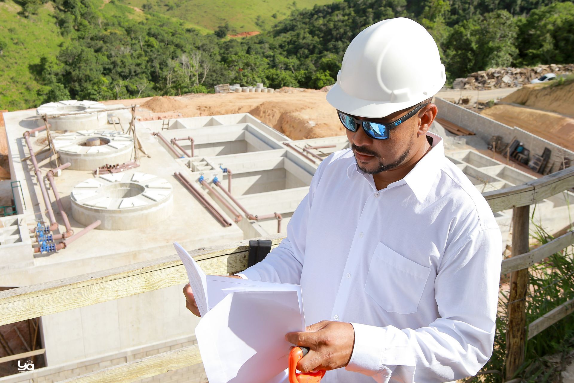 Um homem usando capacete e óculos de sol está olhando para um pedaço de papel.