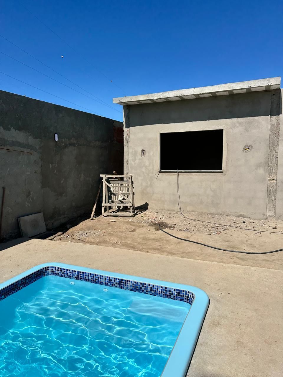 Uma piscina em frente a um prédio em construção