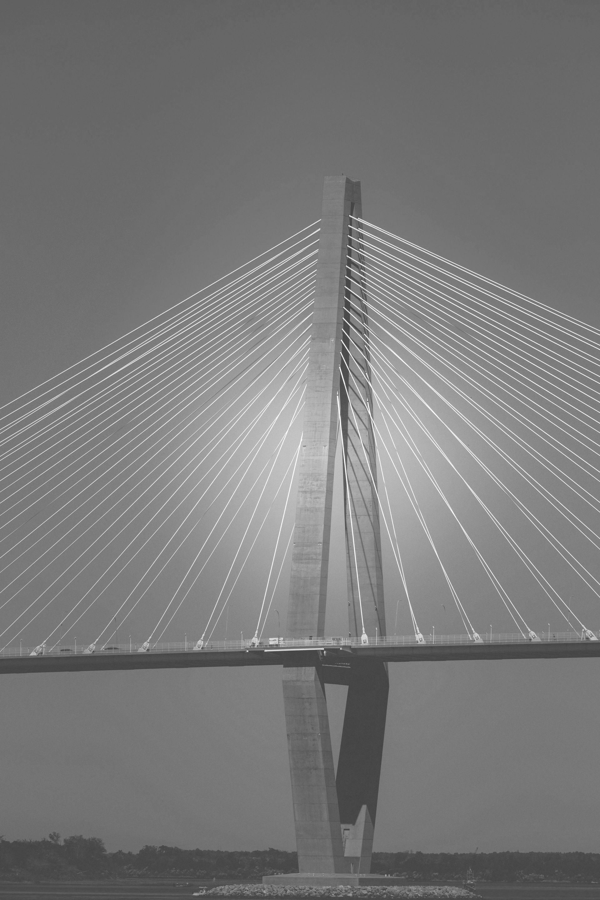 A black and white photo of a bridge over a body of water.